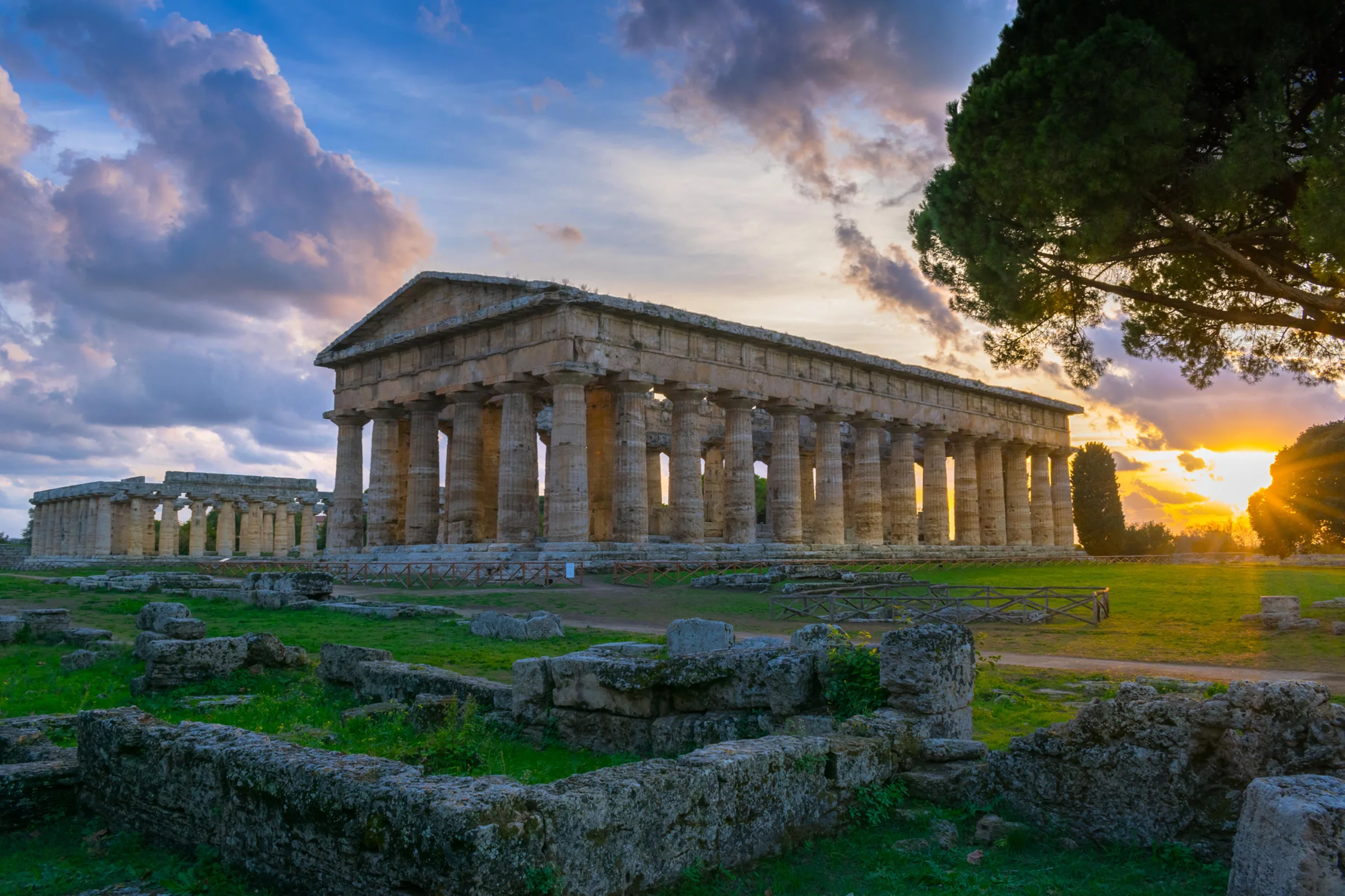 Templi di Paestum illuminati dalla luce calda del tramonto nel Parco Archeologico